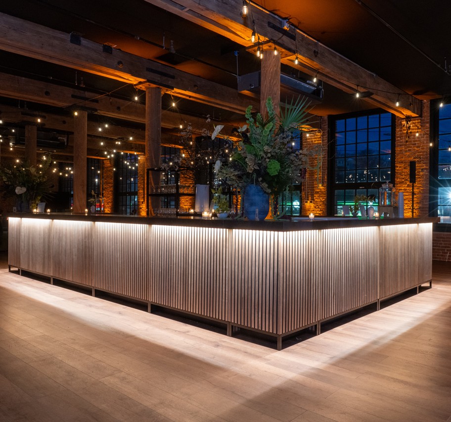 Beautiful illuminated bar at The Mills with exposed brick walls, string lights, and modern industrial design