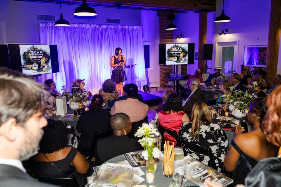 Formal gala presentation event with purple lighting and round table seating