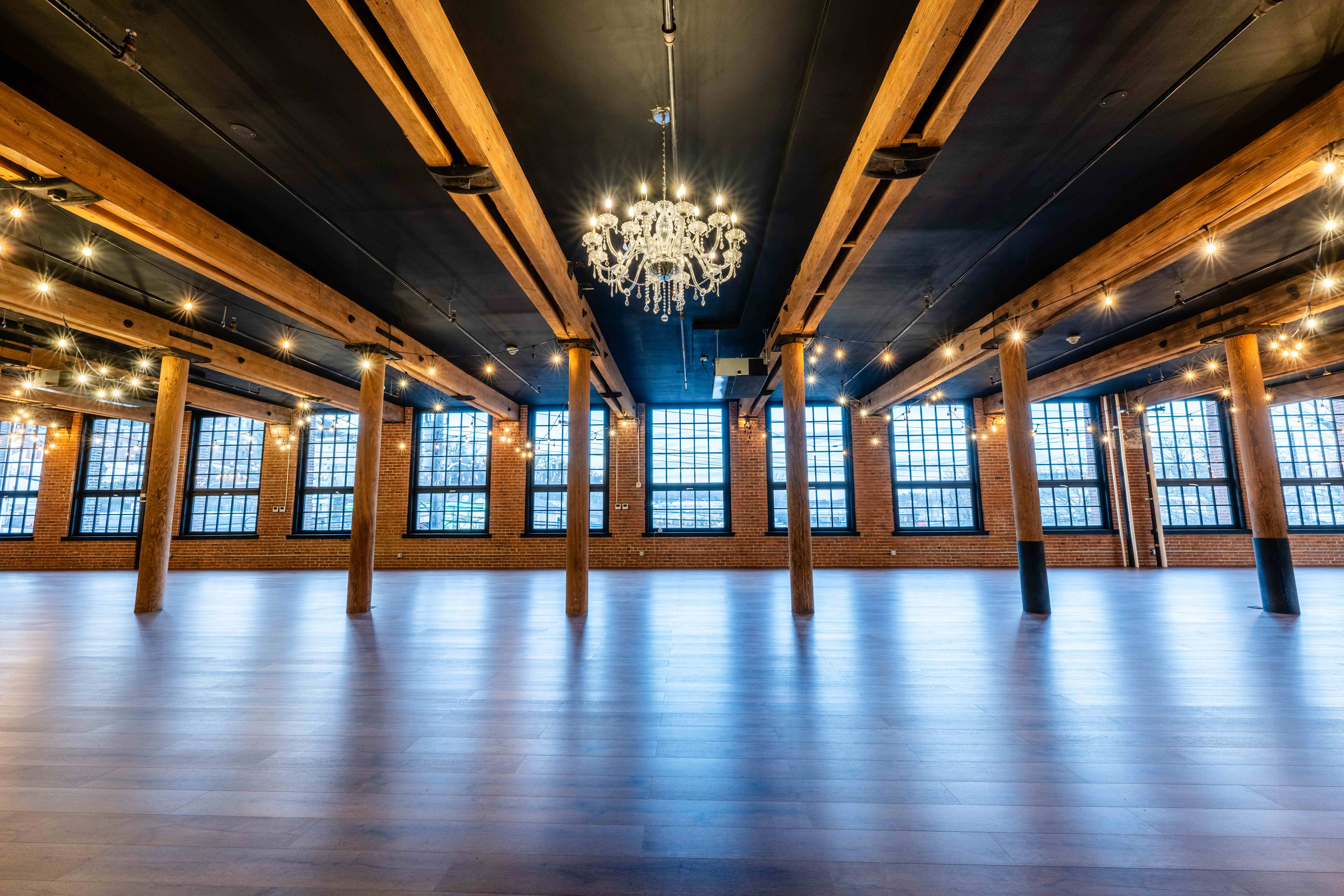 Events at The Mills - Beautiful industrial event space with exposed brick walls, wooden beams, and crystal chandelier