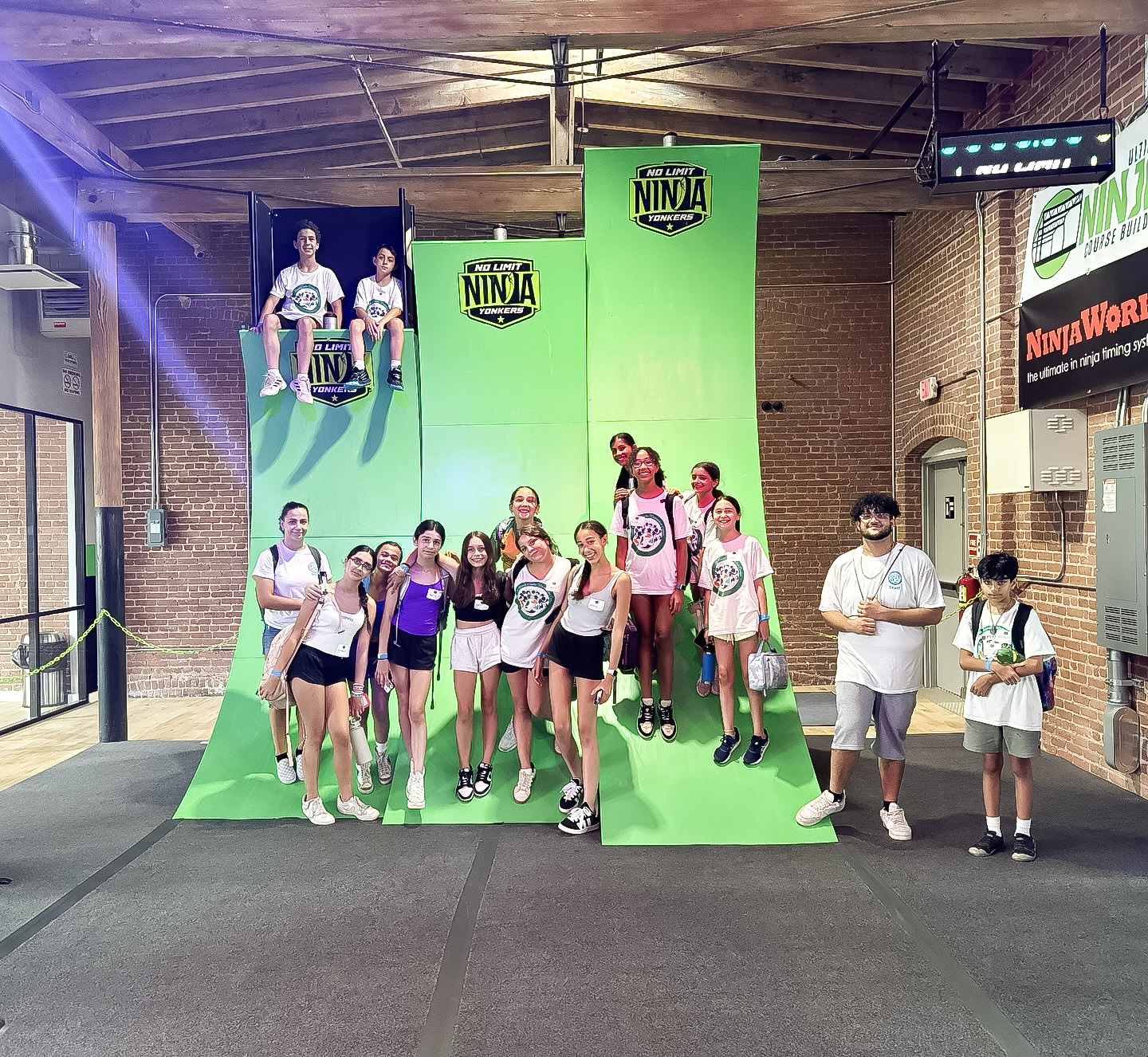Group of kids posing by the warped wall at No Limit Ninja