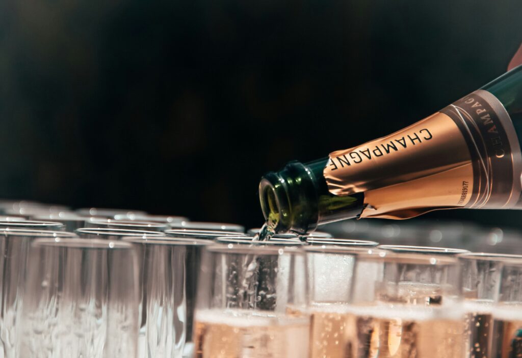 Person pouring champagne into glasses